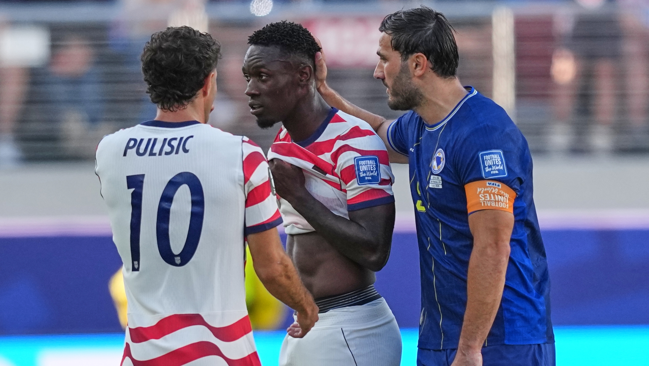 Bosnia's Sead Kolasinac (5) talks to United States' Folarin Balogun, centre, after he was sent from the field as United States' Christian Pulisic (10) watches during the World Cup round of 32 soccer match between the United States and Bosnia in Santa Clara, Calif., near San Francisco, Wednesday, July 1, 2026. (AP Photo/Julio Cortez)