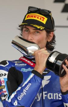 Second placed American rider Joe Roberts of the OnlyFans American Racing Team celebrates with trophy on the podium after the Moto2 race of the Spanish Motorcycle Grand Prix at the Angel Nieto racetrack in Jerez de la Frontera, Spain, Sunday, April 28, 2024. (AP Photo/Jose Breton)