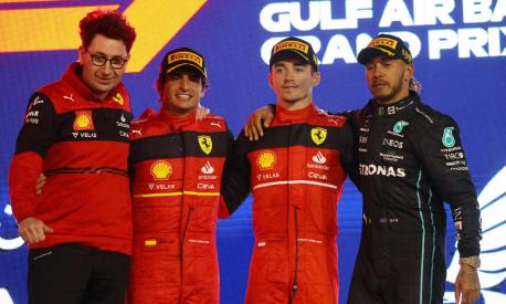 Winner Ferrari's Monegasque driver Charles Leclerc (2nd - R) celebrate on the podium with second place Ferrari's Spanish driver Carlos Sainz Jr ( 2nd - L)  and third placed Mercedes' British driver Lewis Hamilton (R)  and Ferrari team principal Mattia Binotto after the Bahrain Formula One Grand Prix at the Bahrain International Circuit in the city of Sakhir on March 20, 2022. (Photo by Giuseppe CACACE / AFP)