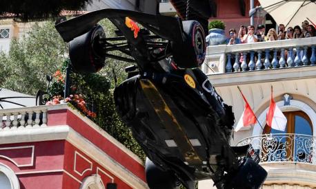 Spectators watch as the car of Red Bull Racing's Mexican driver Sergio Perez is removed from the track after he crashed during the qualifying session of the Formula One Monaco Grand Prix at the Monaco street circuit in Monaco, on May 27, 2023. (Photo by Jeff PACHOUD / AFP)