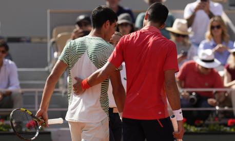 Serbia's Novak Djokovic, right, accompanies Spain's Carlos Alcaraz after he got leg cramps during their semifinal match of the French Open tennis tournament at the Roland Garros stadium in Paris, Friday, June 9, 2023. (AP Photo/Thibault Camus)