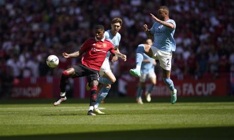 Manchester United's Marcus Rashford, left, is challenged by Manchester City's Kyle Walker, right, and Manchester City's John Stones during the English FA Cup final soccer match between Manchester City and Manchester United at Wembley Stadium in London, Saturday, June 3, 2023. (AP Photo/Dave Thompson)