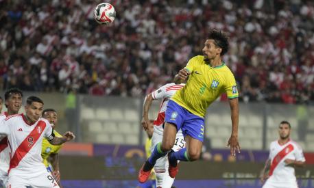 Brazil's Marquinhos, top, scores his side's opening goal against Peru during a qualifying soccer match for the FIFA World Cup 2026 at National stadium in Lima, Peru, Tuesday, Sept. 12, 2023. (AP Photo/Martin Mejia)