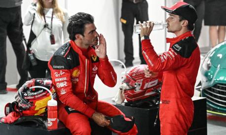 Ferrari's Spanish driver Carlos Sainz Jr (L) speaks with Ferrari's Monegasque driver Charles Leclerc (R) after the qualifying session of the Singapore Formula One Grand Prix night race at the Marina Bay Street Circuit in Singapore on September 16, 2023. (Photo by MOHD RASFAN / AFP)