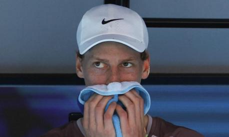 Italy's Jannik Sinner wipes his sweat during a break against Serbia's Novak Djokovic in their men's singles semi-final match on day 13 of the Australian Open tennis tournament in Melbourne on January 26, 2024. (Photo by David GRAY / AFP) / -- IMAGE RESTRICTED TO EDITORIAL USE - STRICTLY NO COMMERCIAL USE --