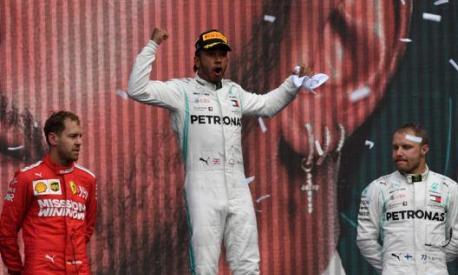 Lewis Hamilton esulta tra Vettel e Bottas. Afp