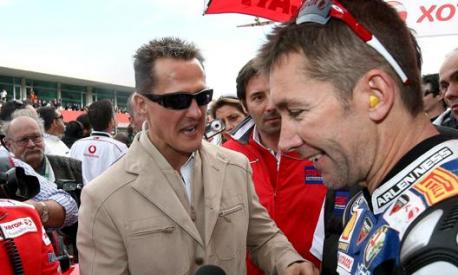 Michael Schumacher si complimenta con Troy Bayliss a Portimao nel 2008. Epa