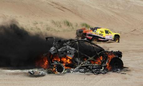 Una vettura a fuoco nel corso di una Dakar. Epa