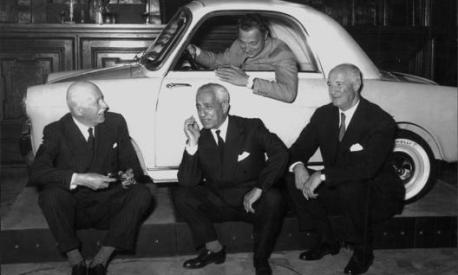 Gianni Agnelli nel 1957 al volante della Bianchina, durante la presentazione della vetturetta a Milano. Seduti, da sinistra: Alberto Pirelli, Vittorio Valletta e Giuseppe Bianchi. Publifoto