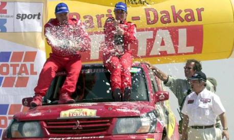 Da sinistra il copilota Andreas Schulz e la pilota Jutta Kleinschmidt sul Mitsubishi Pajero dopo la vittoria della Dakar 2001. Ap