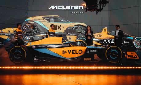 A handout picture released on February 11, 2022 by McLaren shows British driver Lando Norris (L) and McLaren's Australian driver Daniel Ricciardo (2nd L) posing beside the McLaren MCL36 Formula One racing car for the 2022 season. (Photo by McLAREN / AFP) / RESTRICTED TO EDITORIAL USE - MANDATORY CREDIT "AFP PHOTO / MCLAREN" - NO MARKETING NO ADVERTISING CAMPAIGNS - DISTRIBUTED AS A SERVICE TO CLIENTS