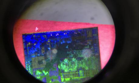 FILE - A Chinese microchip is seen through a microscope set up at the booth for the state-controlled Tsinghua Unigroup project which is driving China's semiconductor ambitions during the 21st China Beijing International High-tech Expo in Beijing, China, on May 17, 2018. Chips are a top priority in the ruling Communist Party's marathon campaign to end China's reliance on technology from the United States, Japan and other suppliers Beijing sees as potential economic and strategic rivals. If it succeeds, business and political leaders warn that might slow down innovation, disrupt global trade and make the world poorer. (AP Photo/Ng Han Guan, File)