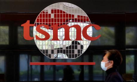 (FILES) This file photo taken on January 29, 2021 shows a man walking past the company logo of the world's largest semiconductor maker Taiwan Semiconductor Manufacturing Company (TSMC) in Hsinchu. - Consumer goods from smartphones to consoles could rise in price due to microchip shortages caused by a "perfect storm" of coronavirus-driven demand, supply chain disruptions and trade war stockpiling, experts warned on February 18, 2021. (Photo by Sam Yeh / AFP) / TO GO WITH Asia-economy-semiconductors-technology,FOCUS by Sam REEVES