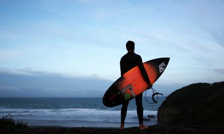 Un surfista solitario controlla il mare. Ph. Fiona Goodall/Getty Images
