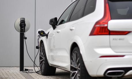 (FILES) In this file photo taken on March 2, 2021 a Volvo XC60 hybrid car is seen plugged into a charging point outside a Volvo dealership in Reading, west of London. - Britain, on June 14, 2022, axed its £1,500 ($1,800) subsidy for buyers of new plug-in cars as it focuses on other types of electric vehicles, but the news drew anger from the auto sector. (Photo by Ben STANSALL / AFP)
