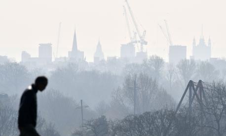 A visitor walks at Primrose Hill as a high air pollution warning was issued for London on March 24, 2022. (Photo by JUSTIN TALLIS / AFP)