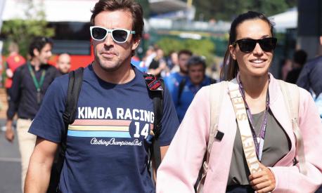 Alpine's Spanish driver Fernando Alonso (L) and  and his grirlfriend Austrian journalist Andrea Schlager walk to the Paddock ahead of the Spa-Francorchamps racetrack on August 25, 2022. - The Formula One Belgian Grand Prix will take place on August 28, 2022. (Photo by Kenzo TRIBOUILLARD / AFP)