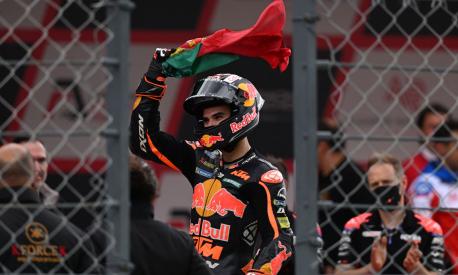 KTM Portuguese rider Miguel Oliveira waves a Portuguese flag after competing in the MotoGP Portuguese Grand Prix at the Algarve International Circuit in Portimao on April 24, 2022. (Photo by PATRICIA DE MELO MOREIRA / AFP)