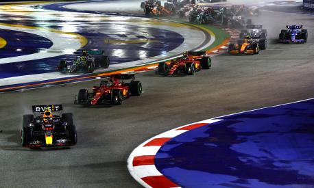 SINGAPORE, SINGAPORE - OCTOBER 02: Sergio Perez of Mexico driving the (11) Oracle Red Bull Racing RB18 leads Charles Leclerc of Monaco driving the (16) Ferrari F1-75 and the rest of the field at the start during the F1 Grand Prix of Singapore at Marina Bay Street Circuit on October 02, 2022 in Singapore, Singapore. (Photo by Mark Thompson/Getty Images,)