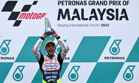 Sterilgarda Husqvarna Max's British rider John McPhee celebrates his victory on the podium for the Malaysian Grand Prix Moto3 race at the Sepang International Circuit in Sepang on October 23, 2022, ahead of the MotoGP Malaysian Grand Prix motorcycle race. (Photo by MOHD RASFAN / AFP)