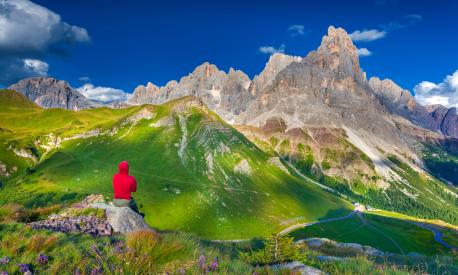 Climber admiring of the landscape of Pale di San Martino, Trentino - Dolomites, Italy. Cimon della Pala mountain ridge.