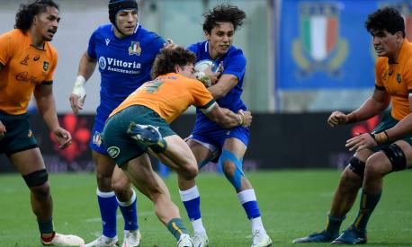 Australia's wing Mark Nawaqanitawase (Front L) tackles Italy's full back Ange Capuozzo during the rugby union Test match between Italy and Australia on November 12, 2022 at the Artemio-Franchi stadium in Florence, Tuscany. (Photo by Filippo MONTEFORTE / AFP)