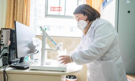 This photo taken on December 29, 2022 shows a health worker preparing a dose of CanSino Biologics inhalable Covid-19 coronavirus vaccine in Bijie, in China's southwestern Guizhou province. (Photo by AFP) / China OUT