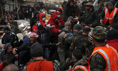 Civil defense workers and security forces carry an earthquake victim as they search through the wreckage of collapsed buildings in Hama, Syria, Monday, Feb. 6, 2023. A powerful earthquake has caused significant damage in southeast Turkey and Syria and many casualties are feared. Damage was reported across several Turkish provinces, and rescue teams were being sent from around the country. (AP Photo/Omar Sanadiki)