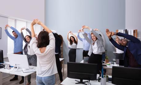Happy Multi-ethnic Businesspeople Raising Hands Doing Stretching Exercise In Office