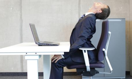 Office occupational disease prevention - business man exercising at workstation