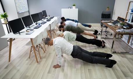 Group Of People Doing Pushups Exercise At Workplace