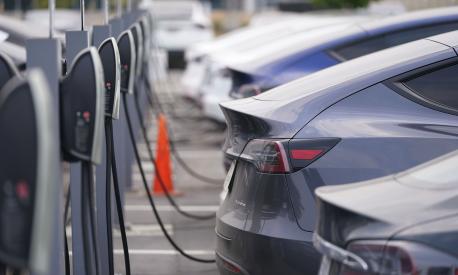 FILE - This Aug. 23, 2020 photo shows a long line of unsold 2020 models charge outside a Tesla dealership in Littleton, Colo. Starting Jan. 1, 2023, many Americans will qualify for a tax credit of up to $7,500 for buying an electric vehicle. The credit, part of changes enacted by the Inflation Reduction Act, is designed to spur EV sales and reduce greenhouse emissions.  (AP Photo/David Zalubowski, File)