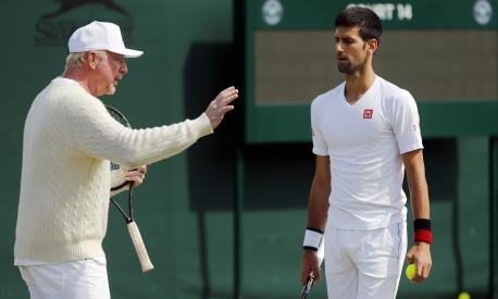 FILE - Novak Djokovic, of Serbia, right, speaks with his coach Boris Becker before resuming his men's singles match against Sam Querrey of the U.S on day six of the Wimbledon Tennis Championships in London, July 2, 2016. Tennis great Boris Becker has been sentenced to 2 1/2 years in prison for illicitly transferring large amounts of money and hiding assets after he was declared bankrupt. The three-time Wimbledon champion was convicted earlier this month on four charges under the Insolvency Act and had faced a maximum sentence of seven years in prison. (AP Photo/Ben Curtis, File)