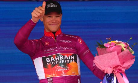 Bahrain - Victorious's Italian rider Jonathan Milan celebrates his best sprinter's cyclamen jersey on the podium after the ninth stage of the Giro d'Italia 2023 cycling race, a 35 km individual time trial between Savignano sul Rubicone and Cesena, on May 14, 2023. (Photo by Luca Bettini / AFP)