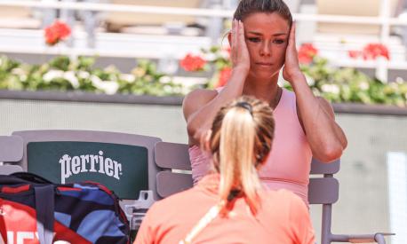 Italy's Camila Giorgi speaks with medical staff member as she plays against US Jessica Pegula during their women's singles match on day four of the Roland-Garros Open tennis tournament at the Court Philippe-Chatrier in Paris on May 31, 2023. (Photo by Thomas SAMSON / AFP)