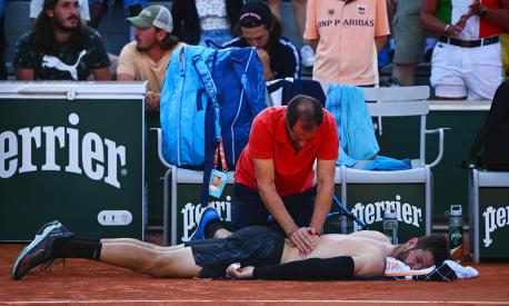 PARIS, FRANCE - JUNE 01: Andrea Vavassori of Italy receives treatment during a break between sets against Olivieri Genaro Alberto of Argentina in the Men's Singles Second Round match on Day Five of the 2023 French Open at Roland Garros on June 01, 2023 in Paris, France. (Photo by Clive Mason/Getty Images)