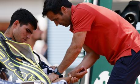 Spain's Carlos Alcaraz receives medical assistance during his semifinal match of the French Open tennis tournament against Serbia's Novak Djokovic at the Roland Garros stadium in Paris, Friday, June 9, 2023. (AP Photo/Jean-Francois Badias)
