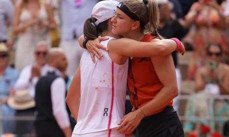 Poland's Iga Swiatek (L) comforts Czech Republic's Karolina Muchova after her victory during their women's singles final match on day fourteen of the Roland-Garros Open tennis tournament at the Court Philippe-Chatrier in Paris on June 10, 2023. (Photo by Thomas SAMSON / AFP)