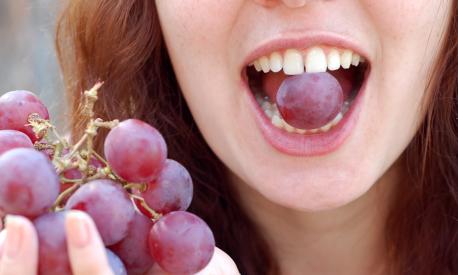 The women eats grapes.