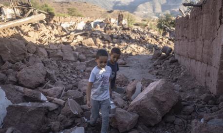 Moroccan boys, Rayan and Ali walk amidst the rubble of their home which was damaged by the earthquake, in Ijjoukak village, near Marrakech, Morocco, Saturday, Sept. 9, 2023. A rare, powerful earthquake struck Morocco, sending people racing from their beds into the streets and toppling buildings in mountainous villages and ancient cities not built to withstand such force. (AP Photo/Mosa'ab Elshamy)