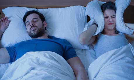 Man snoring in the bed because of night apnoea sleep disorder