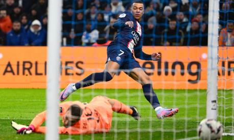 TOPSHOT - Paris Saint-Germain's French forward Kylian Mbappe scores his team's third goal during the French L1 football match between Olympique Marseille (OM) and Paris Saint-Germain (PSG) at the Velodrome stadium in Marseille, southern France on February 26, 2023. (Photo by Christophe SIMON / AFP)