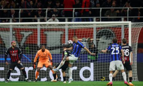 MILAN, ITALY - MAY 10: Edin Dzeko of FC Internazionale scores the team's first goal whilst under pressure as Mike Maignan of AC Milan looks on during the UEFA Champions League semi-final first leg match between AC Milan and FC Internazionale at San Siro on May 10, 2023 in Milan, Italy. (Photo by Alex Grimm/Getty Images)