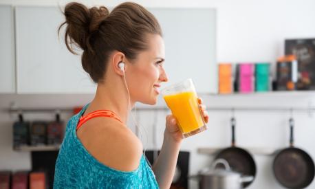 In her modern kitchen, a woman in profile is about to drink her freshly-made smoothie, which is packed with vitamins. A healthy lifestyle is so much fun.