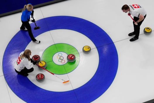 Switzerland's Briar Schwaller-Huerlimann, left, and Yannick Schwaller, right, compete against Estonia's Marie Kaldvee, center, and Harri Lill during a curling mixed doubles session at the 2026 Winter Olympics in Cortina d'Ampezzo, Italy, Wednesday, Feb. 4, 2026. (AP Photo/David J. Phillip)    Associated Press / LaPresse Only italy and spain