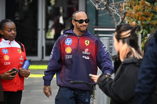 Ferrari's British driver Lewis Hamilton rides a scooter in the paddock ahead of the Formula One Chinese Grand Prix at the Shanghai International Circuit in Shanghai on March 12, 2026. (Photo by GREG BAKER / AFP)