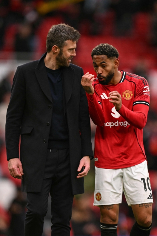 Manchester United's Brazilian striker #10 Matheus Cunha (R) speaks with Manchester United's English interim head coach Michael Carrick (L) at the end of the English Premier League football match between Manchester United and Aston Villa at Old Trafford in Manchester, north west England, on March 15, 2026. (Photo by Oli SCARFF / AFP) / RESTRICTED TO EDITORIAL USE. No use with unauthorized audio, video, data, fixture lists, club/league logos or 'live' services. Online in-match use limited to 120 images. An additional 40 images may be used in extra time. No video emulation. Social media in-match use limited to 120 images. An additional 40 images may be used in extra time. No use in betting publications, games or single club/league/player publications. /
