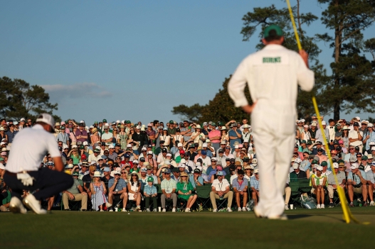  Patrons watch as Rory McIlroy of Northern Ireland lines up a putt on the 18th green during the third round of the 2026 Masters Tournament at Augusta National Golf Club on April 11, 2026 in Augusta, Georgia.   Maddie Meyer/Getty Images/AFP (Photo by Maddie Meyer / GETTY IMAGES NORTH AMERICA / Getty Images via AFP)