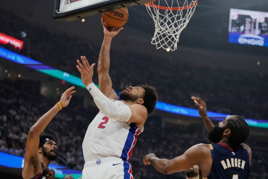 Detroit Pistons guard Cade Cunningham (2) shoots between Cleveland Cavaliers center Jarrett Allen, left, and guard James Harden, right, in the second half of Game 3 of a second-round NBA playoffs basketball series Saturday, May 9, 2026 in Cleveland. (AP Photo/Sue Ogrocki)