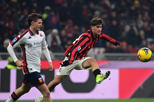 AC Milan's Italian midfielder #30 Mattia Liberali (R) shoots the ball past Genoa’s Danish midfielder #32 Morten Frendrup (L) during the Italian Serie A football match between AC Milan and Genoa at the San Siro Stadium in Milan, on December 15, 2024. (Photo by Piero CRUCIATTI / AFP)